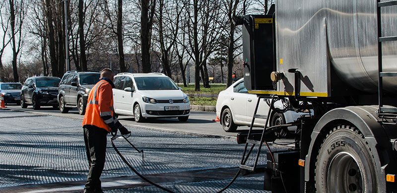 working spraying asphalt emulsion on the road