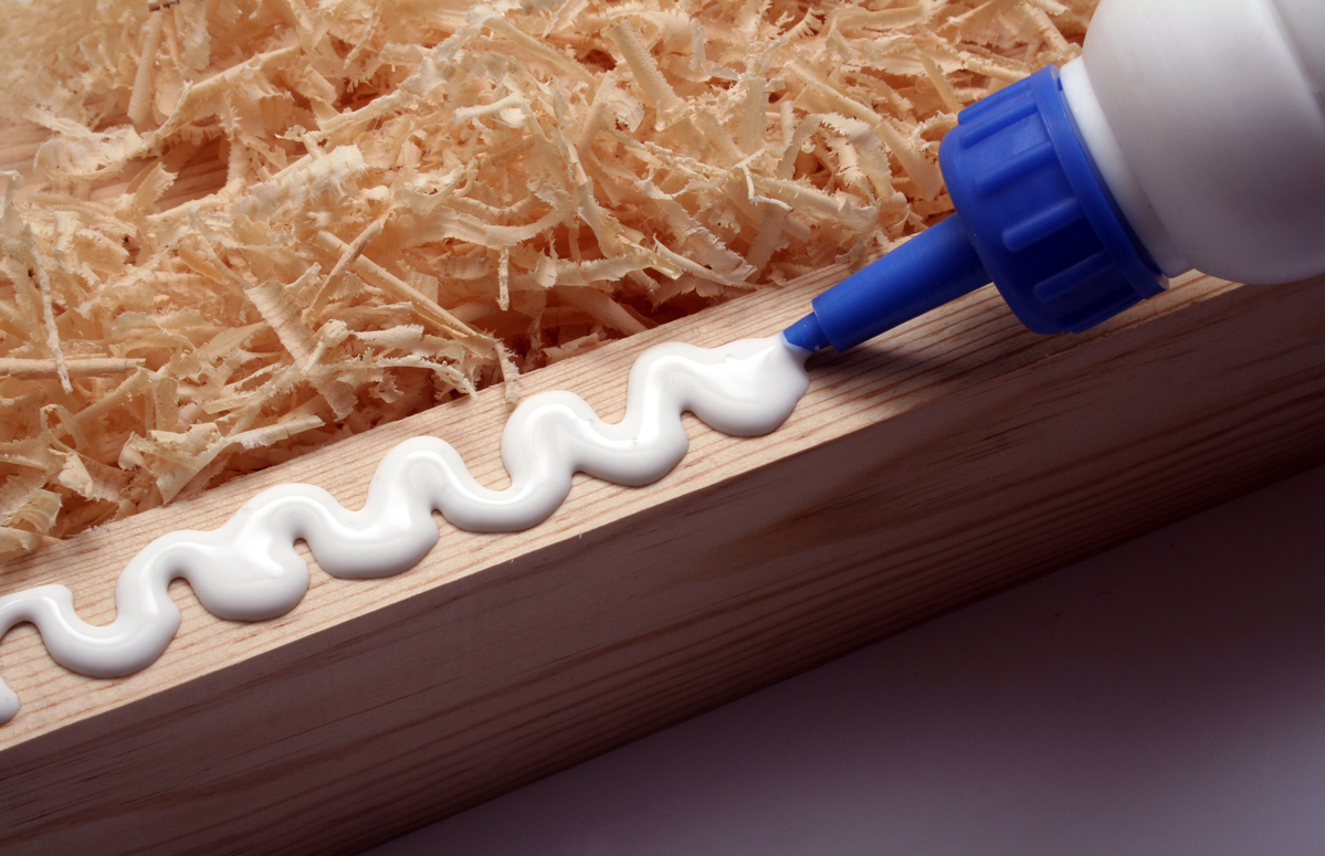 image of bottle of wood glue being squeezed onto the edge of a piece of wood