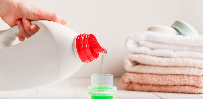 detergent being poured into little cup for laundry