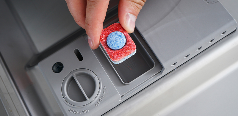 detergent pod being placed into dish washer