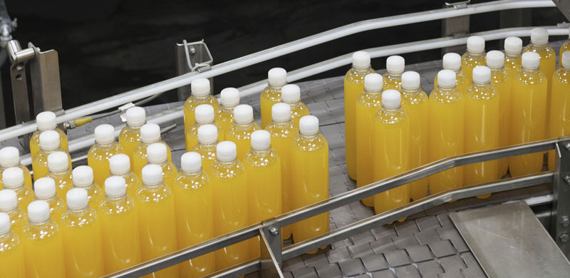 High fructose corn syrup in bottles on conveyer belt