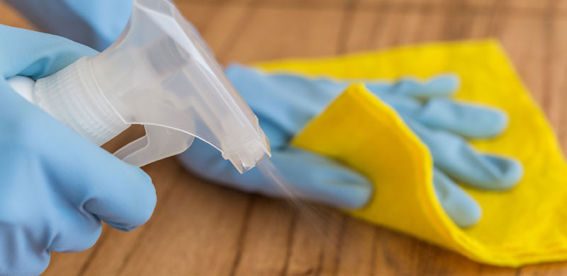 Cleaning chemical being sprayed onto table