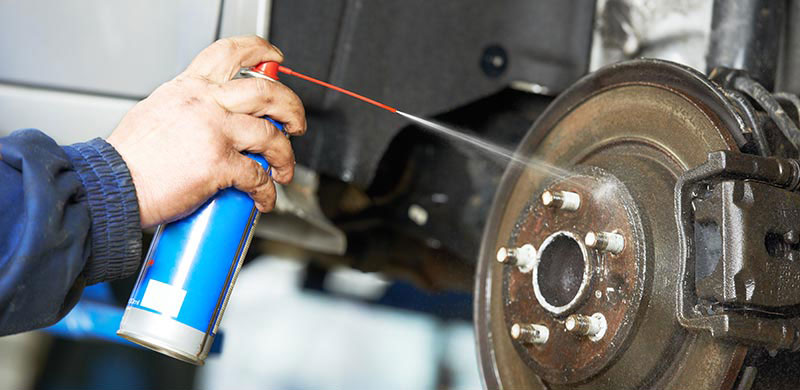 Person spraying solvent on a wheel