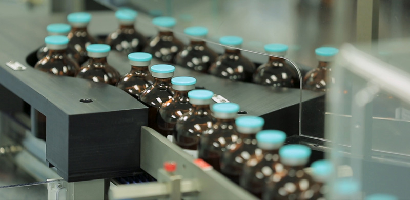 Vaccines in vials on a conveyer belt