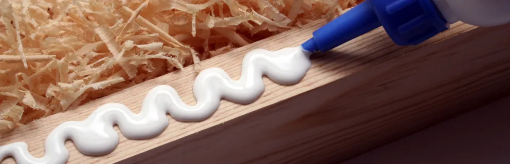 image of bottle of wood glue being squeezed onto the edge of a piece of wood