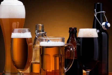 Various mugs of foamy amber beer