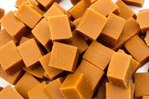 A small pile of square blocks of caramel candy