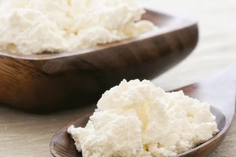 Quark cheese in a wooden bowl and spoon