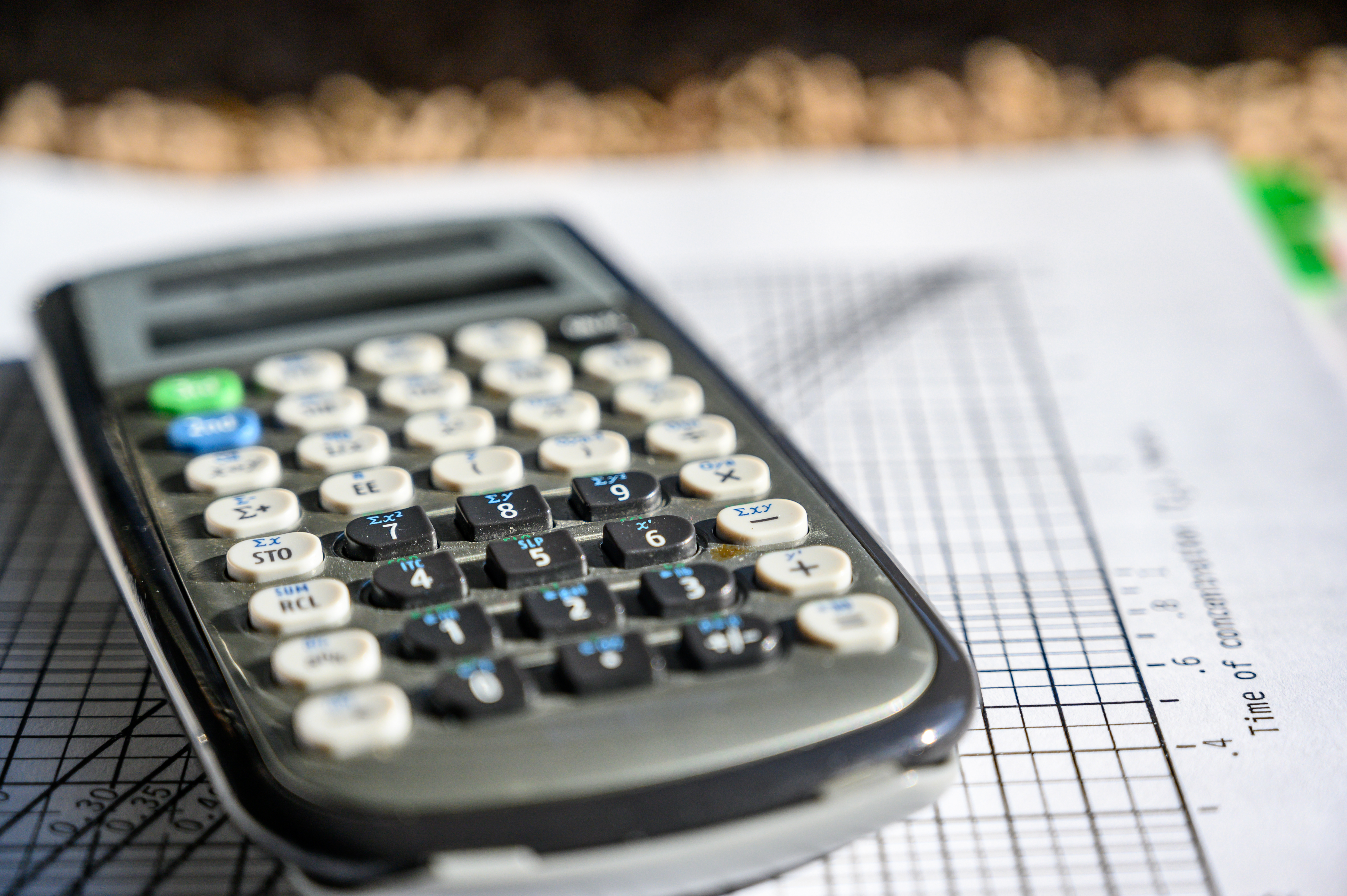 En miniräknare ovanpå rutat papper